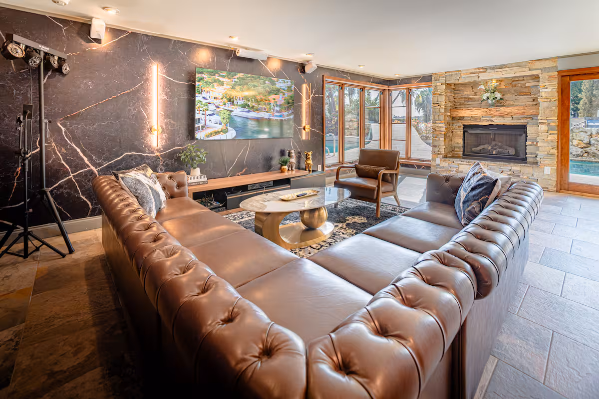Glass-wrapped great room with white sectional and water views