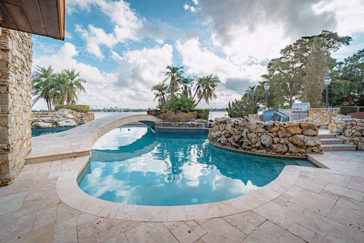 Lagoon pool wrapped in boulders with the house beyond