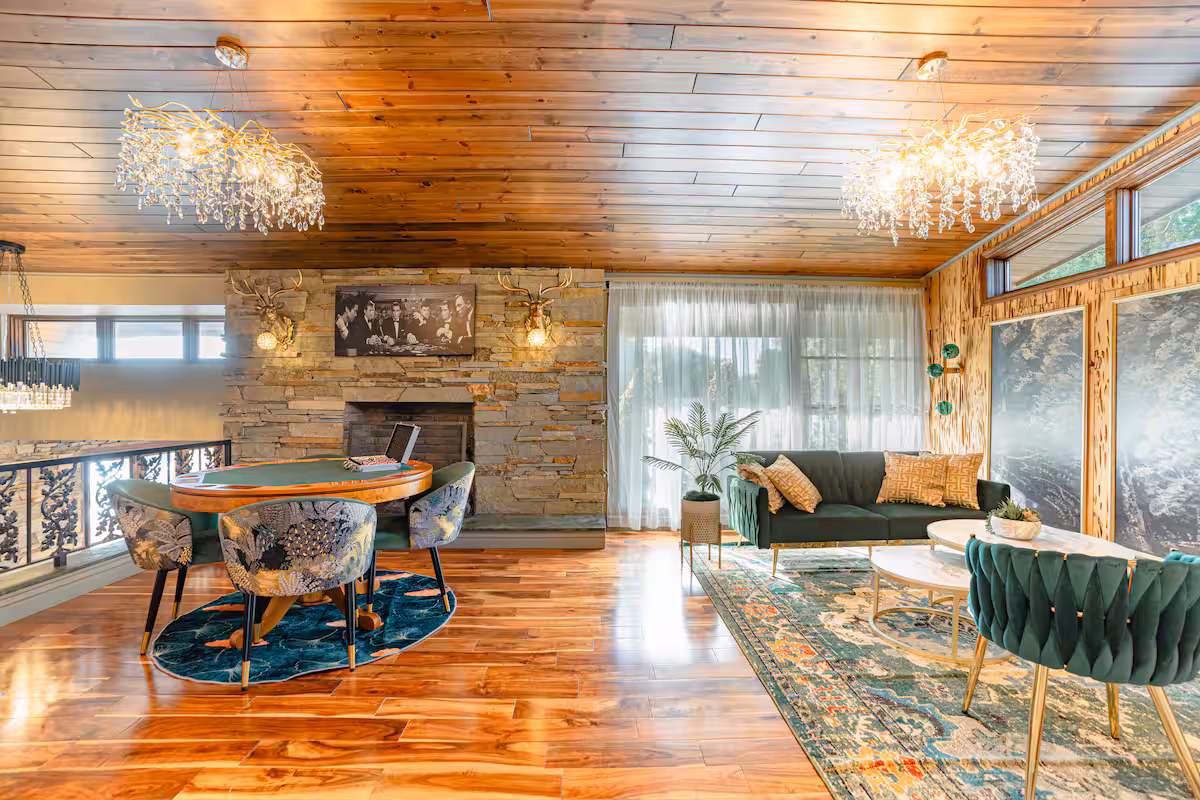 Open-plan living space in white oak with green velvet chairs
